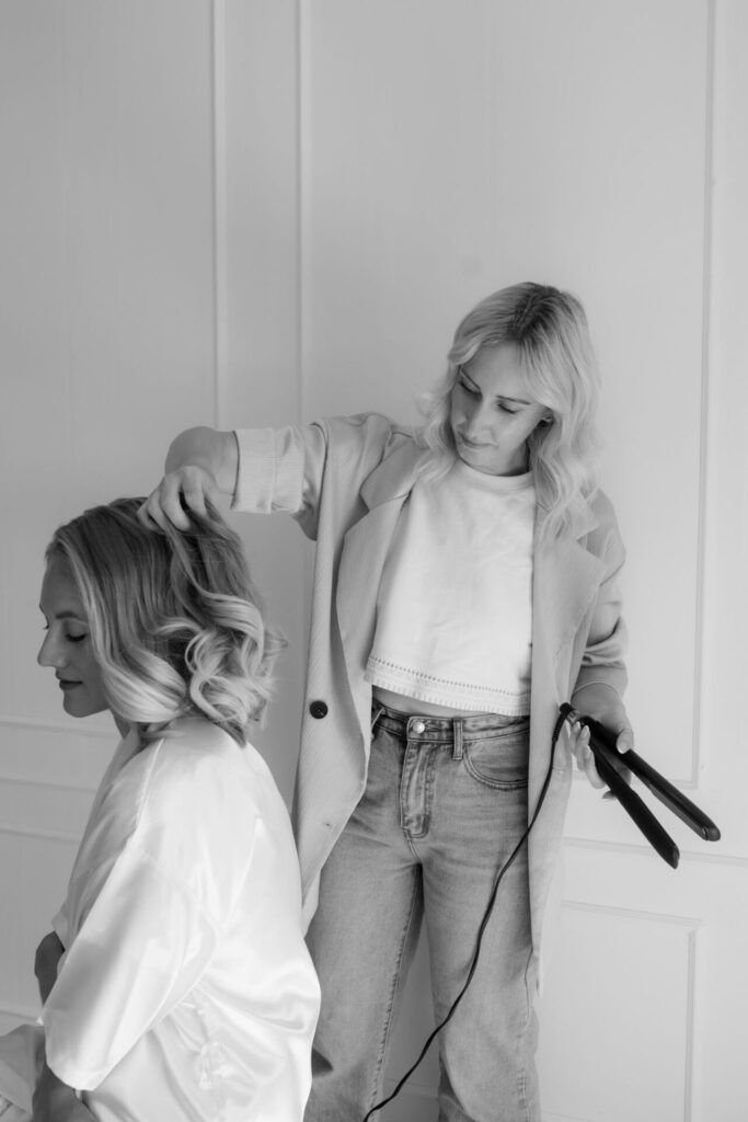 Photograph of Amy Roman creating a wedding hair style for a bride